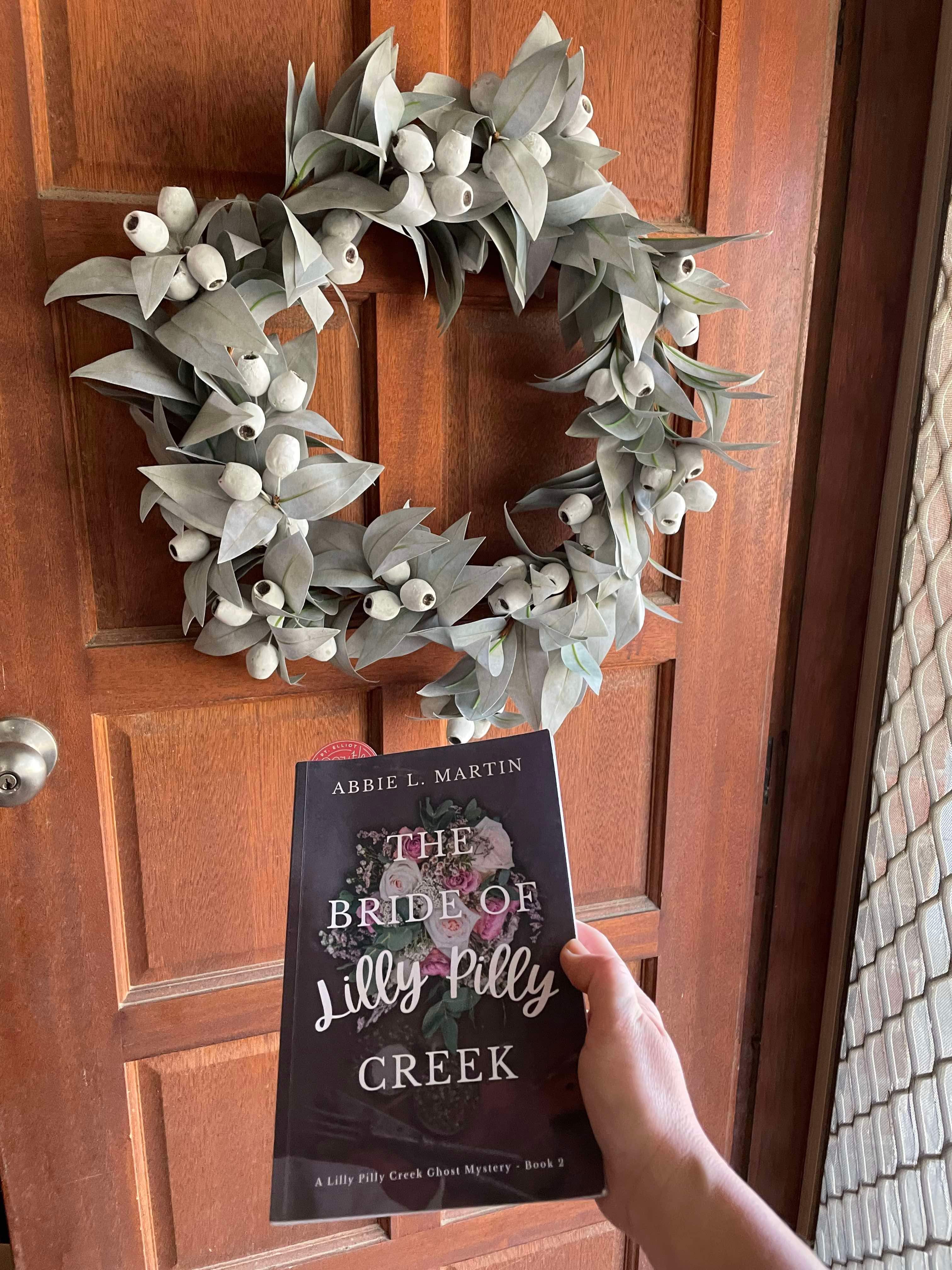 Reader holding Australian Cozy Mystery - The Bride of Lilly Pilly Creek 